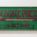 Green and red painted sign 'Aldgate Press'